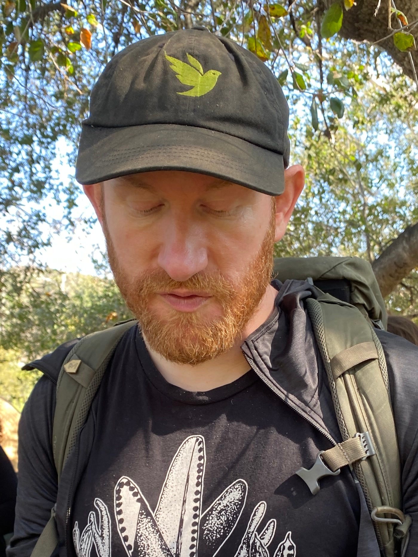The mycologist Alan Rockefeller on a mushroom walk, in a cap and field pack.