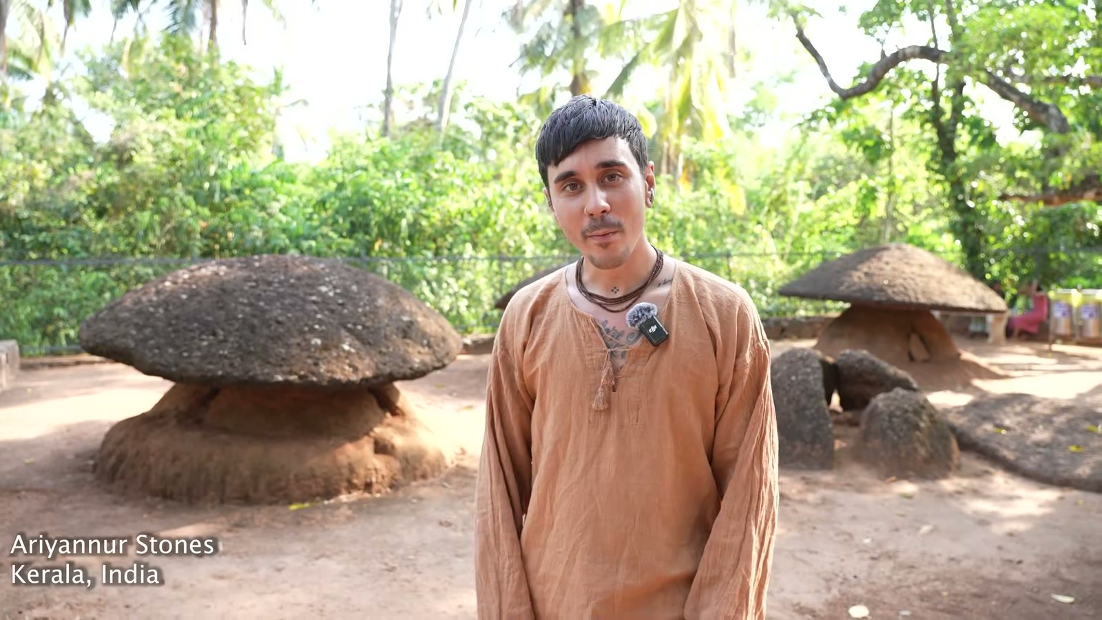 Dakota Wint standing among the Ariyannur umbrella-stones — mushroom-shaped megaliths — in Kerala, India.