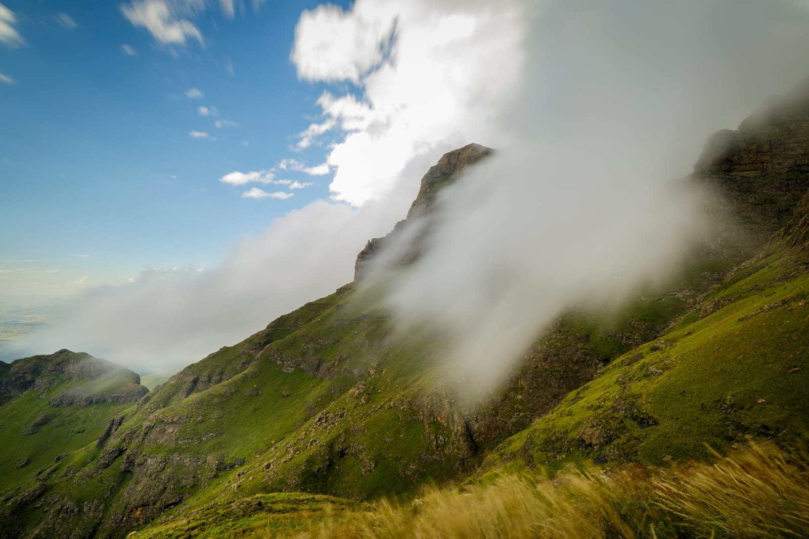 Cloud pouring through a gap between high basalt peaks in the Drakensberg escarpment.