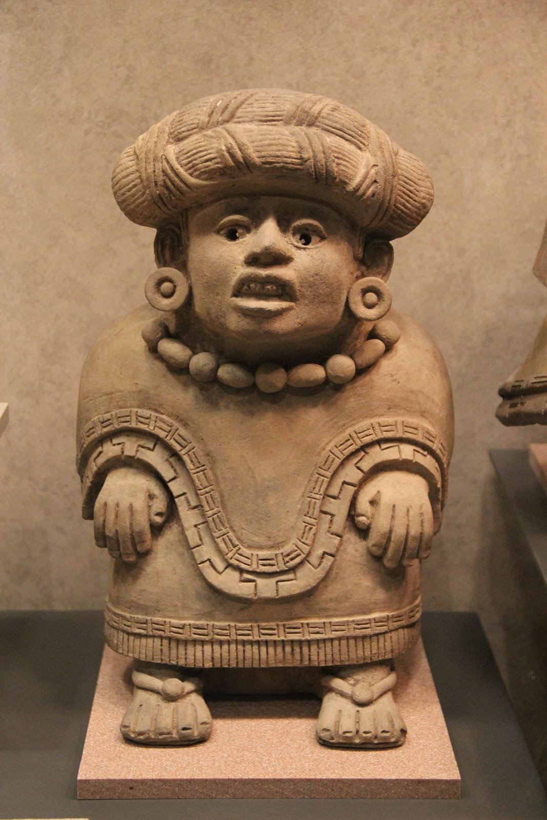 A Zapotec ceramic funerary urn in the form of a seated figure, from Monte Albán.